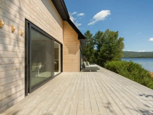 Un chalet canadien en bord de lac, ouvert à la lumière