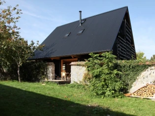 Cette maison s'est glissée entre deux murs en pierres 