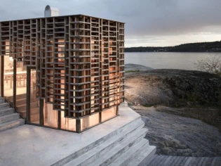 Une maison en bois polymère se dresse sur un plateau rocheux