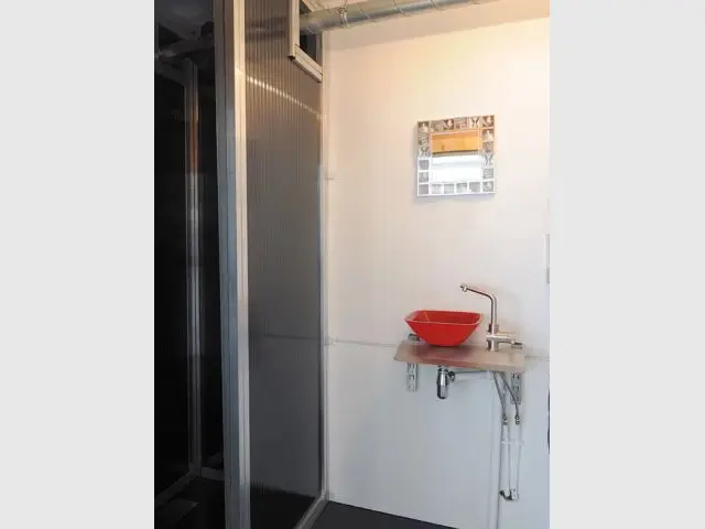 Une salle de douche et son lavabo rouge - Maison containers