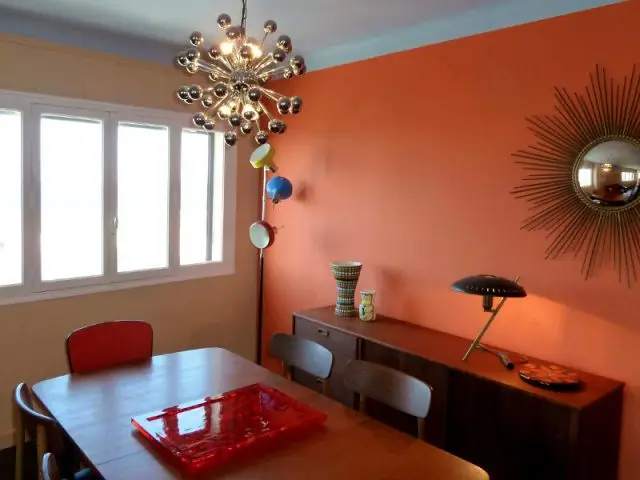 Salle à manger - Mur orange et suspension lumineuse - Appart fifties coloré