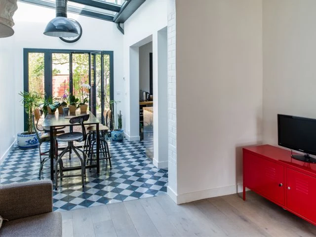 Une salle à manger sous une verrière - Une maison de ville au décor industriel