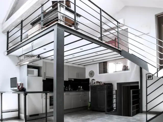 Une mezzanine dont l'installation résulte directement de l'implantation de la cuisine - Reconversion d'une ancienne papeterie en loft contemporain