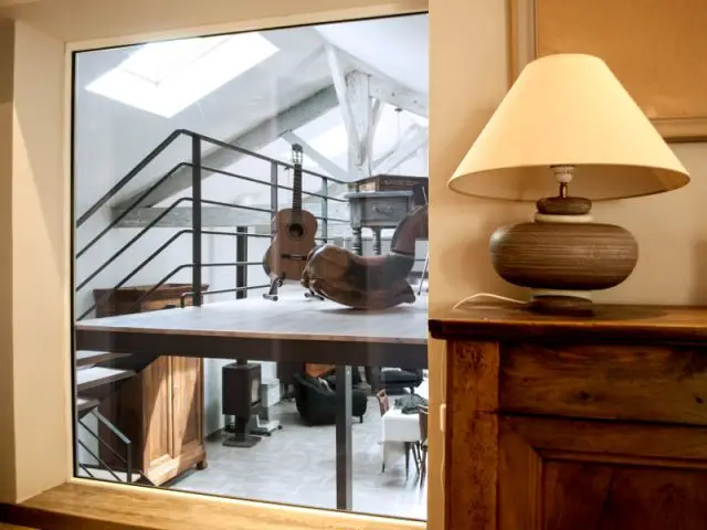 Une grande vitre qui relie visuellement les différents espaces du loft - Reconversion d'une ancienne papeterie en loft contemporain