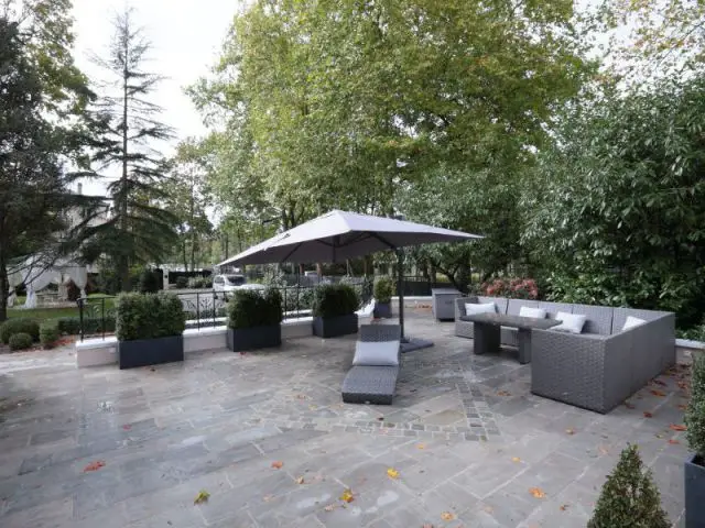 Une terrasse lounge comme espace de réception ombragé - Une demeure du 19ème siècle retrouve sa fraicheur et son authenticité 