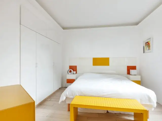 Une chambre entièrement blanche égayée par des touches de jaune - Un appartement fonctionnel et rafraichissant aux touches de couleurs pop