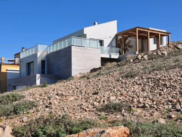 Un aspect cabanon pour une intégration parfaite dans le paysage local - Une villa cachée parmi les rochers au bord de la mer