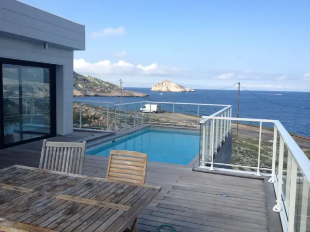 Une piscine avec vue sur la mer sur le toit du garage  - Une villa cachée parmi les rochers au bord de la mer