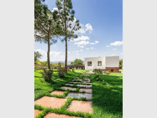 Un chemin de pierre qui mène à une maison cachée dans la nature - Courtyard House in Trapani by Studio 4e