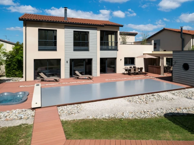 Une élégante intégration dans le paysage - Une couverture de piscine dissimulée dans une terrasse paysagère