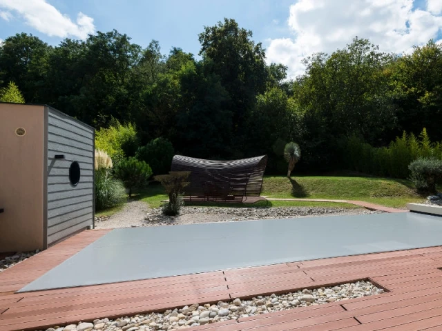 Une pergola en forme de vague - Une couverture de piscine dissimulée dans une terrasse paysagère