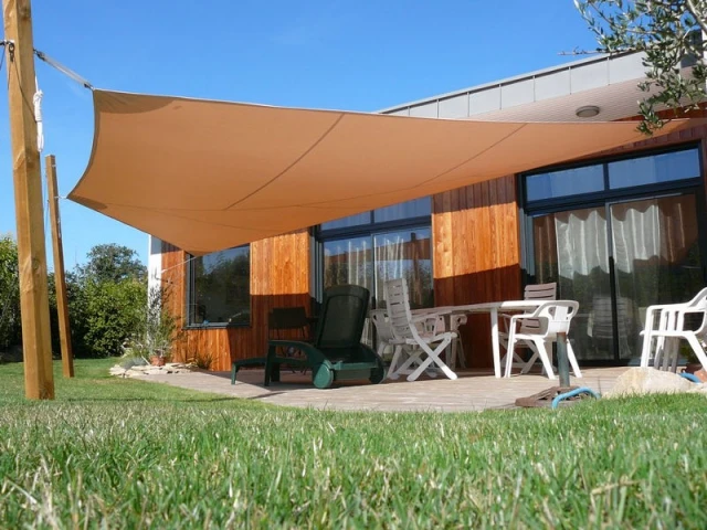 Un voile d'ombrage aux mâts en bois assortis à la maison - Voile d'ombrage