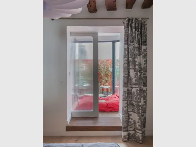 Un sas surélevé en guise d'entrée  - Appartement parisien atypique avec jardin