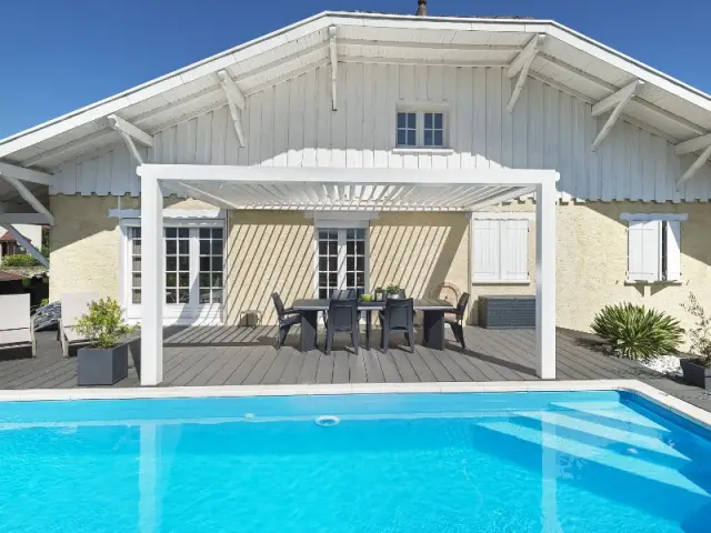 Une installation extérieure pour un minimum d'entretien - Une pergola contemporaine magnifie une bâtisse