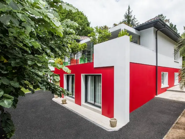 Une isolation thermique par l'extérieure efficace - un rouge flamboyant pour la façade d'une maison