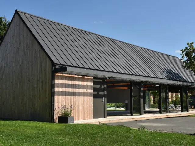 Une toiture zinc et un bardage bois pour un extérieur épuré  - Un abri de piscine inspiré des hangars agricoles