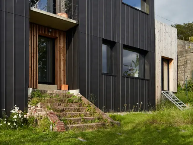 Accès direct sur le jardin pour la partie nuit   - Une maison en zinc noir posée sur un mur en brique