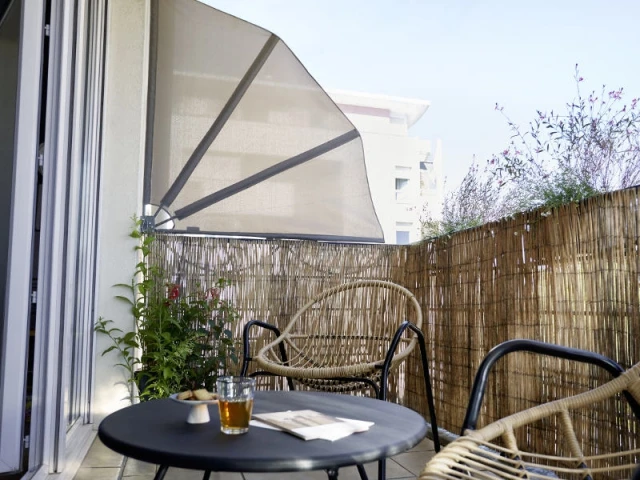 Un éventail pour se cacher du soleil sur un balcon