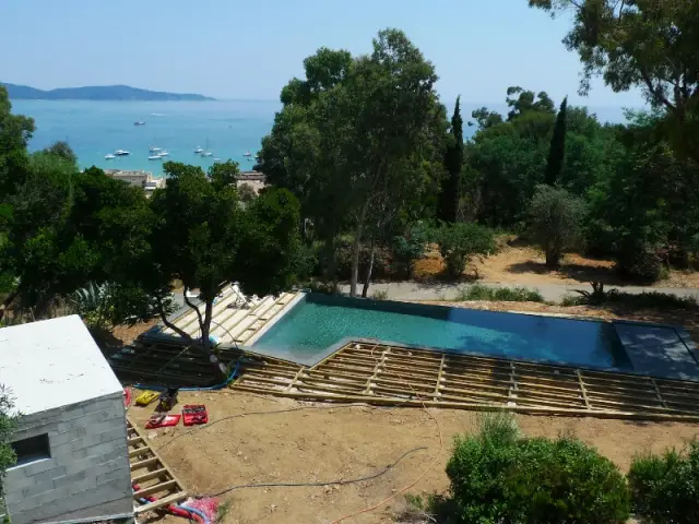 Une piscine enveloppée par une terrasse en bois