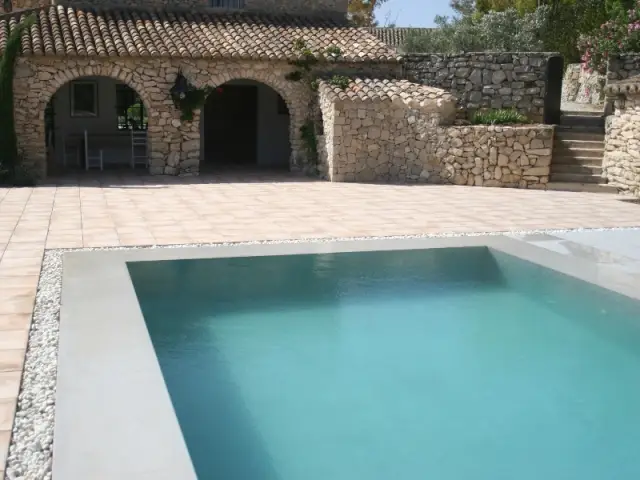 La piscine est partiellement cerclée de galets 