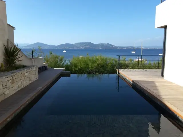 Piscine après la rénovation, avec revêtement mosaïque de Bali et plages en bois