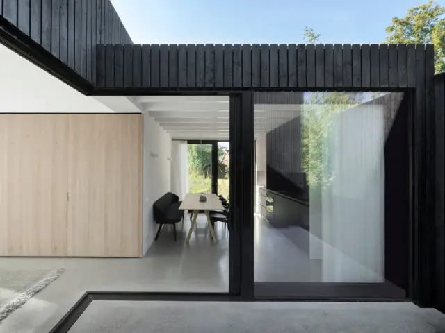 Façade noire et baies vitrées XXL viennent donner un côté contemporain à la maison