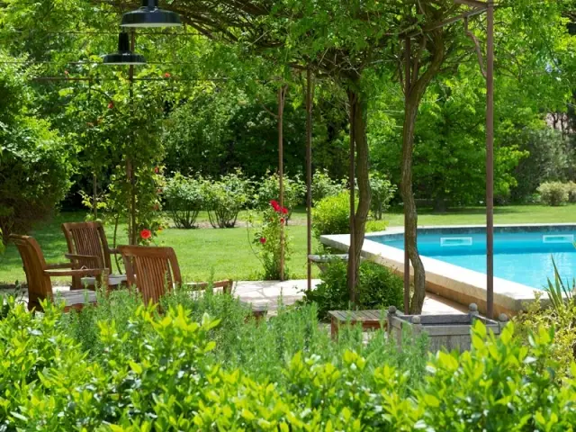 Une jolie piscine bordée d'une terrasse fleurie