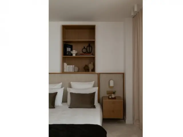 La chambre avec sa tête de lit intégrée au mur