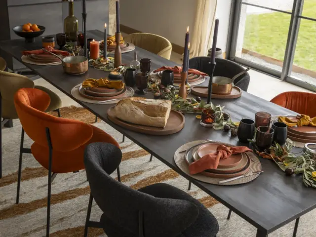 Un joli centre de table avec des branches d'olivier, des marrons et des oranges séchées