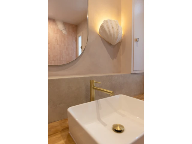 Avec son applique coquillage et les zelliges de couleur rose, la salle de bain à des allures de boudoir