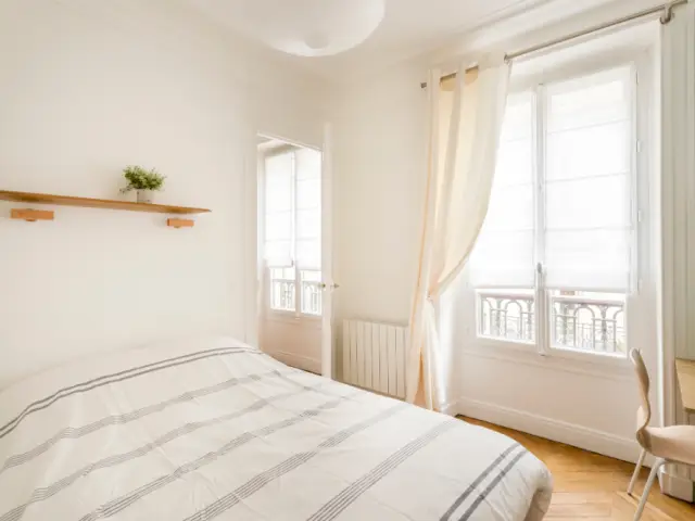 Une chambre optimisée avec un lit deux places, un placard et un espace bureau