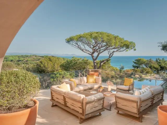 Une terrasse qui donne sur la piscine et la mer