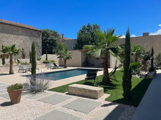 Un jardin avec piscine et terrain de pétanque